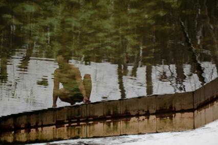 Старый Новый год жители столицы Ставропольского края отметили ледяным заплывом. На снимке: отражение в воде мужчины, который собирается купаться в ледяной воде.