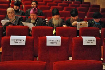 Форум Русского народного собора в Ставрополе. На снимке: ряд кресел в концертном зале, на креслах бумажки с надписью: `служебное место`, сзади сидят священники.