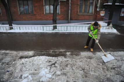 Уборка снега и льда с улиц Москвы. На снимке: дворникс лопатой.