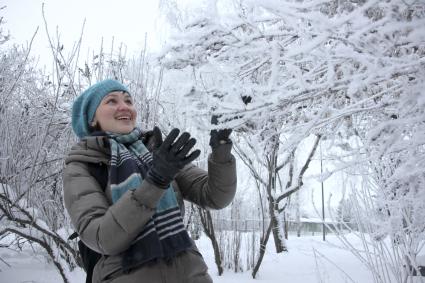 Девушка любуется заснеженными деревьями.