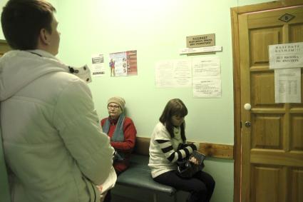 Люди стоят в очереди травмпункта в ожидании повторного приема врача травматолога.