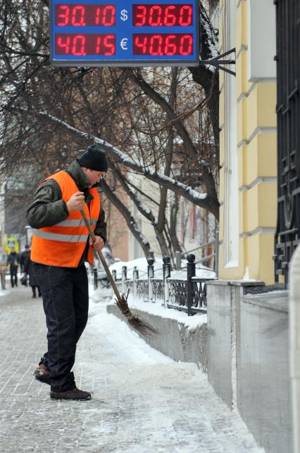 Последствия снегопада. На снимке: дворник убирает снег.