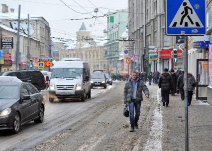 Слякоть. На снимке: прохожие на грязном тротуаре.