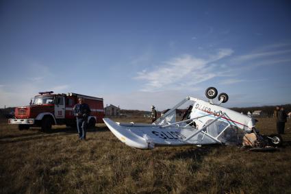 На аэродроме РОСТО Ставрополя потерпел крушение спортивный самолет `Синтал`. На снимке: перевернутый самолет и пожарная машина.