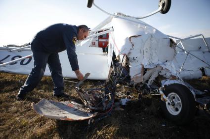 На аэродроме РОСТО Ставрополя потерпел крушение спортивный самолет `Синтал`. На снимке: спасатель МЧС осматривает место крушения.