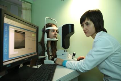 Офтальмолог проверяет зрение у ребенка.
