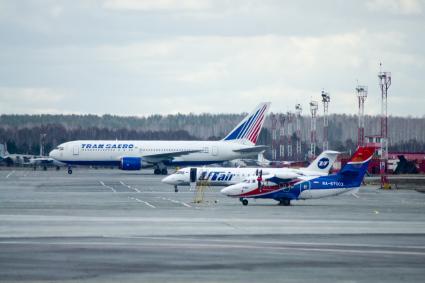 На поле в аэропорту стоят: Самолет Boeing 767-200 авиакомпании `Трансаэро` (на заднем плане), самолет Bombardier CRJ-200 авиакомпании `UTair` (в середине) и самолет Let L-410 UVP-E20 Turbolet авиакомпании `UTair`.