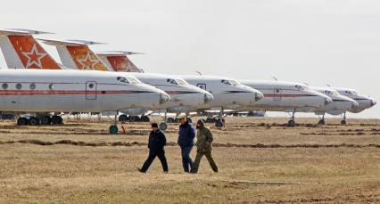 Самолеты Ту-134 на хранении на военном аэродроме. По полю идут военные.