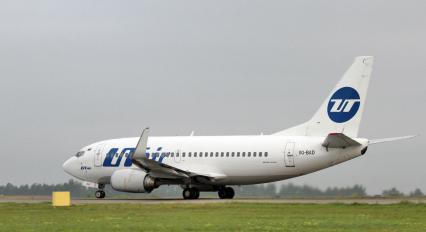 Пассажирский самолет Boeing 737-500 авиакомпания `UTair` на взлетно-посадочной полосе.