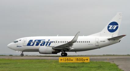 Пассажирский самолет Boeing 737-500 авиакомпания `UTair` на взлетно-посадочной полосе.