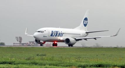 Пассажирский самолет Boeing 737-500 авиакомпания `UTair` на взлетно-посадочной полосе.