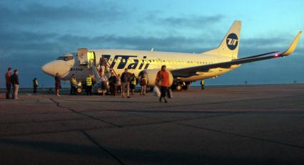 Пассажиры выходят из самолета Boeing 737-500 авиакомпании `UTair`.