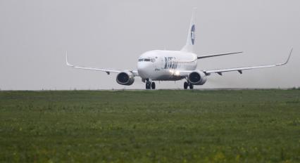 Пассажирский самолет Boeing 737-500 авиакомпания `UTair` на взлетно-посадочной полосе.