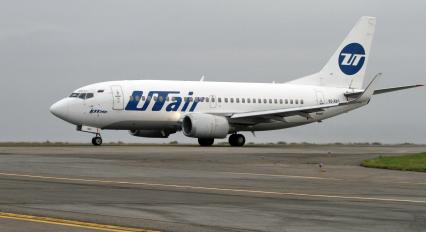 Пассажирский самолет Boeing 737-500 авиакомпания `UTair` на взлетно-посадочной полосе.