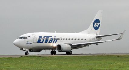 Пассажирский самолет Boeing 737-500 авиакомпания `UTair` на взлетно-посадочной полосе.