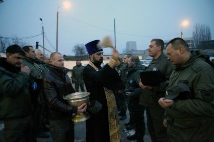 Священник освящает казаков на патрулирование.