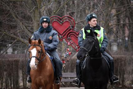 Конный полицейский патруль ППС рядом со скамейкой с сердечками.