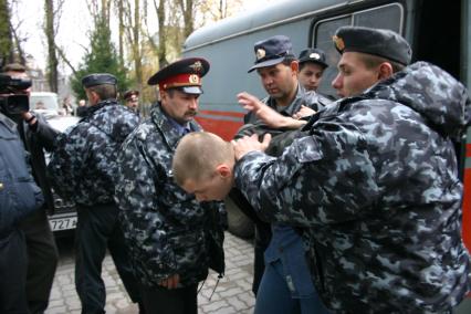 Полицейские полицейские выводят нарушителя из здания суда