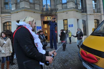 Креативная свадьба 12.12.12. На снимке: молодой человек обливает свадебную `Газель` шампанским.