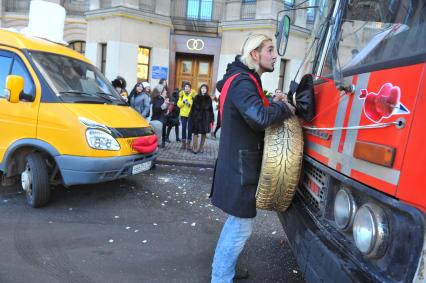 Креативная свадьба 12.12.12. На снимке: молодой человек с автомобильным колесом в руках.