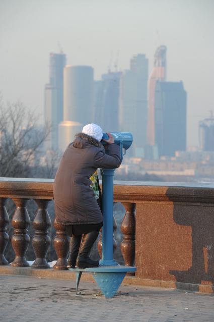 Воробьевы горы. На смотровой площадке городские власти установили пять стационарных биноклей. На снимке: бесплатный стационарный бинокль и женщина.