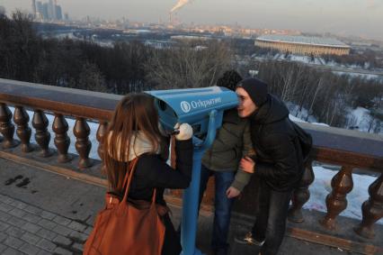 Воробьевы горы. На смотровой площадке городские власти установили пять стационарных биноклей. На снимке: бесплатный стационарный бинокль и студенты.