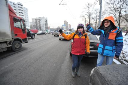 Путешествие автостопом. На снимке: молодые люди голосуют на шоссе.