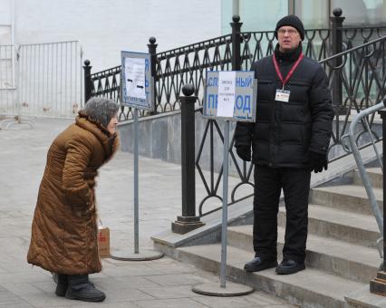 Старушка смотрит на указатель.