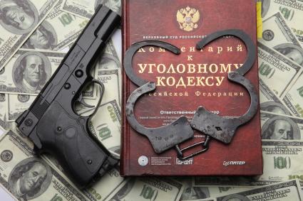Комментарии к уголовному кодексу, пистолет, наручники и доллары США.