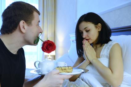 Отношения мужчины и женщины. На снимке: мужчина принес своей любимой женщине кофе в постель