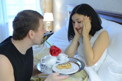 Отношения мужчины и женщины. На снимке: мужчина принес своей любимой женщине кофе в постель