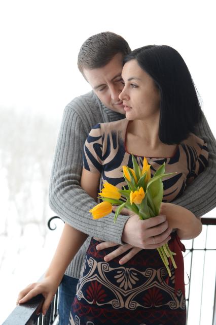 Отношения мужчины и женщины. На снимке: мужчина дарит женщине желтые тюльпаны.