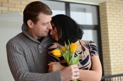Отношения мужчины и женщины. На снимке: мужчина дарит женщине желтые тюльпаны.