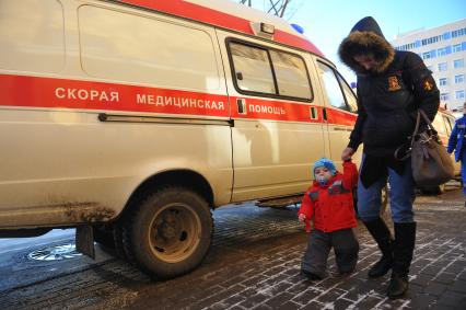 Кареты скорой медицинской помощи и женщина с ребенком.