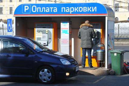 Водитель такси оплачивает парковку через терминал.