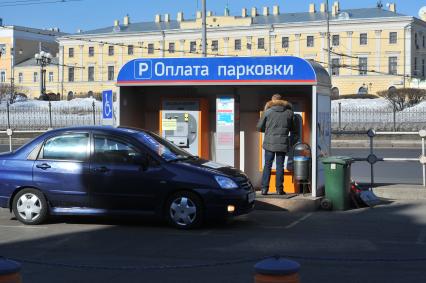 Водитель такси оплачивает парковку через терминал.