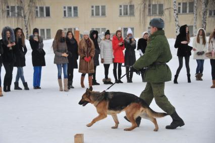 Саперная часть в Подмосковье. Участницы конкурса `Мисс Россия 2013` поздравили военнослужащих с Днем защитника Отечества. На снимке: участницы конкурса и военный кинолог.