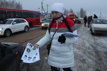 Волонтер раздает объявления по поиску пропавшего ребенка Василисы Галициной.