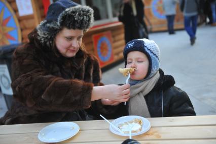 Масленичный фестиваль в Москве. На снимке: ребенок ест блины.