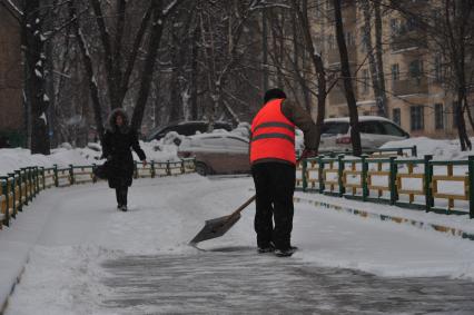 Дворник убирает снег.