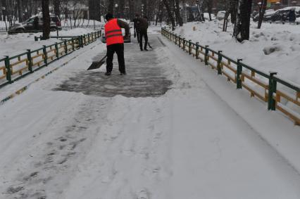 Дворник убирает снег.