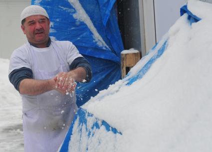 Повар умывает руки снегом.