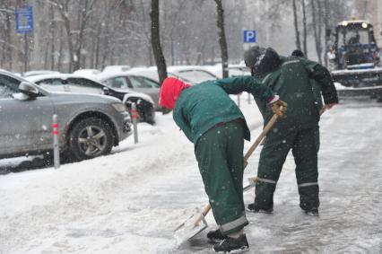 Дворники убирают снег.