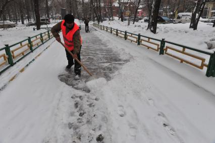 Дворник убирает снег.