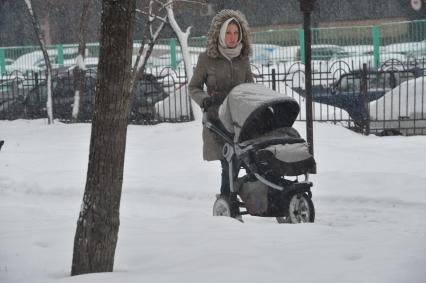 Девушка гуляет с ребенком в Петровском парке.