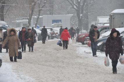 Снегопад. На снимке: люди на улице города.