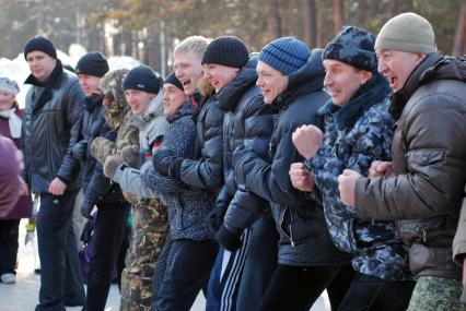 Смеющиеся молодые люди готовятся к конкурсу стенка на стенку.