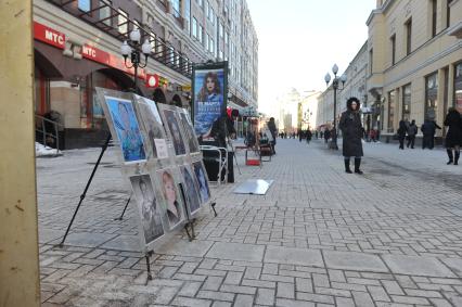 Виды Москвы. Улица Старый Арбат. На снимке: стенд с шаржами и подпись `Портреты, шаржи и фото`.