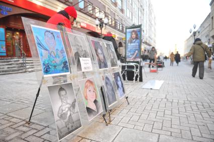 Виды Москвы. Улица Старый Арбат. На снимке: стенд с шаржами и подпись `Портреты, шаржи и фото`.