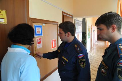 Сотрудники МЧС проводят проверку пожарной безопасности в столичных школах и детских садах перед началом учебного года. На снимке: и. о. начальника второго регионального отдела надзорной деятельности управления по ЮЗАО ГУ МЧС России по г. Москве  Николай Черкасов открывает пожарный ящик.